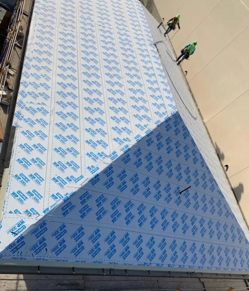 Professional roofers installing underlayment on a metal roof in Kings Point